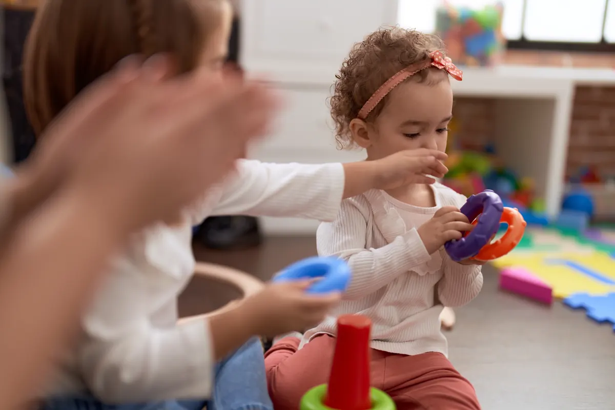 Menina brincando com arcos no chão de uma sala