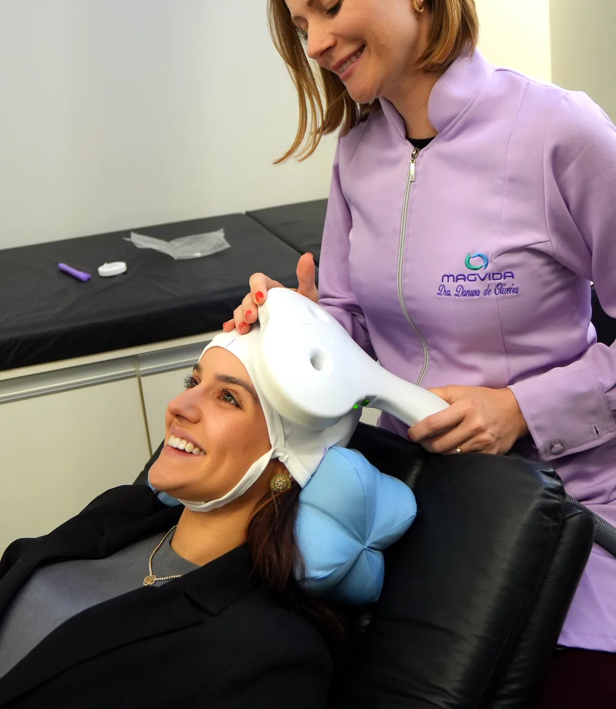 Paciente sorrindo durante sessão de estimulação magnética transcraniana com a fisioterapeuta Danusa Oliveira na Clínica Magvida